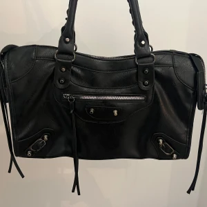 Svart axelväska med dragkedja - As snygg svart axelväska med flera detaljer. Perfekt till skola och fest. Säljer då den tyvärr inte kommer till användning längre. Skriv för frågor eller fler bilder💕💕💕