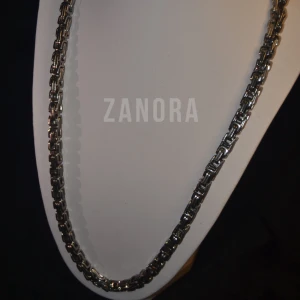 FRI FRAKT | ZANORA | HALSBANDS KEDJA | ROSTFRITT STÅL SILVER TONAD | 6MM - 60CM | - ZANORA Halsbandskedja i rostfritt stål, silvertonad, kombinerar stilren design med hållbarhet. Med en bredd på 6 mm och en längd på 60 cm ger den en perfekt balans mellan elegans och funktion. Kedjan är vattentålig och tålig nog för dagligt bruk, vilket gör den till ett mångsidigt komplement till din smyckessamling. ZANORA, grundat 2024, strävar efter att skapa tidlösa smycken som håller länge. Har du några frågor? Tveka inte att kontakta oss!