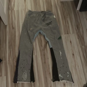 Grå mjukisbyxor från Gallery Dept. - Unika grå mjukisbyxor från Gallery Dept. med konstnärliga färgstänk och tryck. Byxorna har en elastisk midja med snörning och är dekorerade med logotypen på framsidan. 