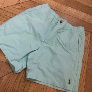Turkos  shorts från Ralph Lauren - Snygga shorts från Ralph Lauren med elastisk midja och knappdetaljer. Perfekta för sommardagar med sin lätta bomullskänsla. Klassisk broderad logga på benet.