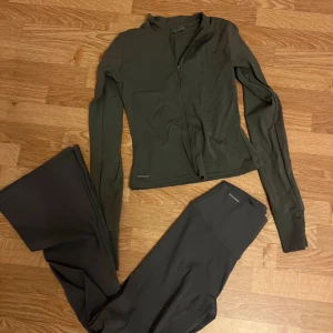 Grått träningsset från MKLIFESTYLE - Grått träningsset från MKLIFESTYLE, jacka med dragkedja framtill och tillhörande flarepants. Materialet är mjukt och stretchigt för optimal rörelsefrihet.