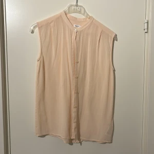 En aprikos färgad blus - Super söt blus från Filippa K i stolek S, stil ren men kan även kläs upp. Super bra plagg att ha i garderoben 