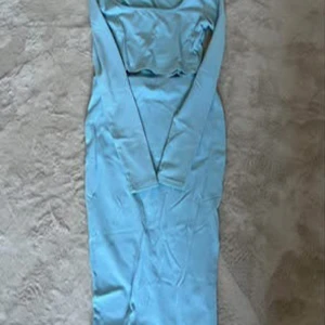 Ljusblå långklänning - Elegant ljusblå långklänning med långärmad design. Perfekt för speciella tillfällen med sin stilrena och sofistikerade look.