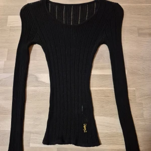Svart ribbad tröja från YSL - Snygg svart ribbad tröja från YSL med lång ärm och rund halsringning. 