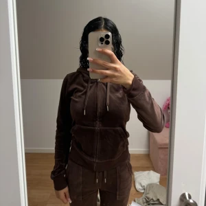 Brun velour hoodie - Mysig brun velour hoodie med dragkedja och huva. Perfekt för en avslappnad stil. Den har långa ärmar och en bekväm passform.