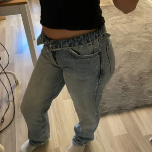 Blå jeans med rynkad midja - Snygga blå jeans med en unik rynkad högmidja. De har en avslappnad passform och klassiska femficksdetaljer. Perfekta för en casual look.