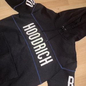 Svart hoodie från Hoodrich - Säljer en svart hoodie från Hoodrich med vit text på bröstet och ärmarna. Storlek xs, nästan helt oanvänd.