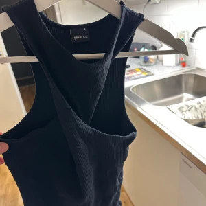 Svart ribbad linnetopp från Gina Tricot - Snygg svart ribbad linnetopp från Gina Tricot. Perfekt för lager-på-lager eller att bära som den är. Den har en stilren design med breda axelband.