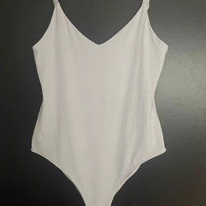 Vit bodysuit från Zara - Vit bodysuit från Zara i storlek M. Använd 1 gång. Inga fel på den, använder bara aldrig den☺️köpt för 200 eller 250 tror jag