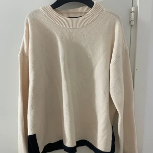Beige stickad tröja från Vero Moda - Jätteskön beige stickad tröja från Vero Moda med svarta detaljer. Tröjan har en liten slits vid ärmarna som är en väldigt snygg detalj. Använd fåtal gånger. Säljer på grund av att den inte kommer till användning. Skriv vid frågor! 