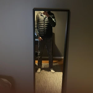 Svart dunväst från Dressmann - Snygg svart dunväst från Dressmann med dragkedja framtill. Perfekt för lager-på-lager under kyliga dagar. Västen har en stilren design och är lätt att matcha med olika outfits.