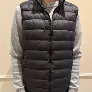 Svart Väst-Uniqlo - Säljer denna stilrena svarta västen från Uniqlo. Väll använd men på ett sparsamt sett. Köpt för ungefär ett år sedan och nu är västen för liten för mig. Liten skråma på bröstet men som är sytt och lagat, inget som man tänker på vid användning.( Se på sista bilden). Köptes för 599kr, mitt pris endast 250kr. Storlek S. Tveka inte på att höra av dig vid minsta fundering.