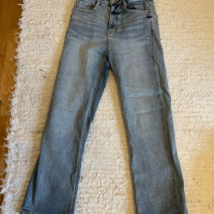 Blå jeans från 77thFlea - Snygga blå jeans från 77thFlea med hög midja och straight fit. Klassisk design med fem fickor och knappgylf.