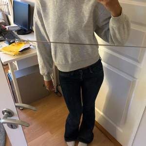 Säljer en supermysig grå sweatshirt i normal passform. Den är perfekt för både chill dagar hemma och när du är ute och rör på dig. Tröjan har långa ärmar och är gjord i ett mjukt material som känns skönt mot huden. Ett måste i garderoben för alla som älskar bekväma kläder!