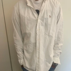 Ralph lauren skjorta strl-M/L - Hej! Jag säljer nu min snygga Ralph lauren skjorta i färgen vit. Den är i bra skick och väldigt snygg och stilren. Vid fler frågor och funderingar är det bara att höra av sig! 
