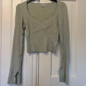Stickad grön topp från bubbleroom  - Endast testad men ej använd  Slits på ärmen 