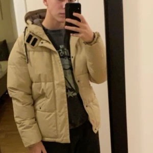 Beige puffjacka - Säljer en snygg beige vinterjacka från Jack & Jones, för den är för liten för mig. Strl S, har lite slitage i en söm på ena axeln, men annars i fint skick.