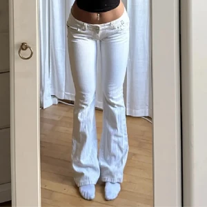 Lågmidjade vita bootcut jeans - Säljer dessa snygga jeans, skicket var fint och är köpte på plick för 600, Jag har aldrig använt dem utom att testa då det var alldeles för stora🤗Materialet är lite glittrigt.  Midja 78 innerbenet 81, vid snabb affär kan pris diskuteras🙌