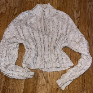 Beige stickad tröja från NA-KD - Säljer en snygg beige stickad tröja från NA-KD. Tröjan har ett flätat mönster som ger en trendig look. Perfekt för kyligare dagar!