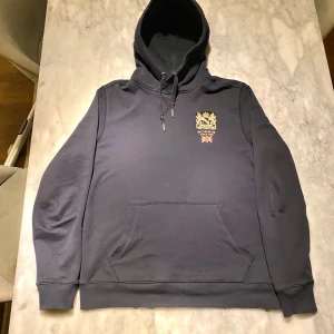 Mörkblå Morris hoodie storlek M - Skick: 8/10, endast en liten defekt på innersidan av luvan. Tröjan är inköpt förra året men inte kommit till så mycket användning. 