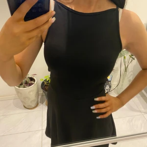 Svart ärmlös klänning - Snygg svart ärmlös klänning med en elegant och enkel design. Perfekt för olika tillfällen med sin klassiska look.