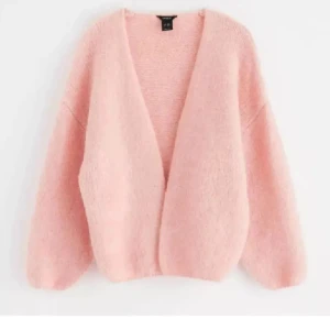 Kofta  - Mysig kofta från Lindex i fluffigt material (den här fast i svart) . Perfekt för kyliga dagar med sin öppna design och långa ärmar. En stilren och bekväm tröja för en avslappnad look.