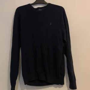 Navy  tröja från Polo Ralph Lauren - Snygg navy  tröja från Polo Ralph Lauren med diskret logga på bröstet. Perfekt för en stilren look. Tröjan har långa ärmar och rund halsringning.