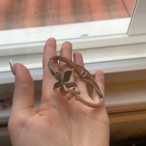 Silverfärgat armband med blomdetalj - Äkta silver men inget nummer inuti för det är återvunnet silver jätte fint armband som man kan öppna och sätta på sig säljer för de är lite för stort för mig men jätte fin är den