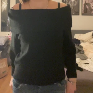 Svart offshoulder tröja från H&M - Säljer en stilren svart offshoulder tröja från H&M. Perfekt för en trendig look med långa ärmar och en bekväm passform. Passar utmärkt till både jeans och kjol.