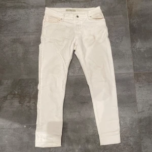 Vita jeans från Mango - Snygga vita byxor från Mango i storlek EUR 40. De har en slim passform med knappar och dragkedja framtill. Perfekta för en stilren look. Fläckar finns samt smutiga fickor, se bilder.