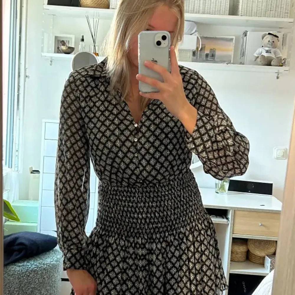 Snygg svart och vit mönstrad klänning med långa ärmar och knappar framtill. Helt slutsåld! Och kostar typ 399 nypris, kan posta direkt!!!. Mekot.