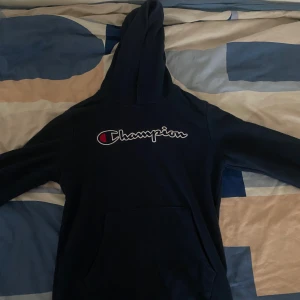 Mörkblå hoodie från Champion - Säljer en snygg mörkblå hoodie från Champion med deras ikoniska logga på bröstet. . Passar bra till både jeans och joggers. Pris kan såklart diskuteras.