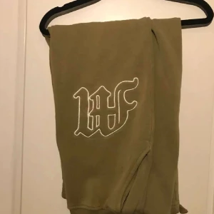 Gröna mjukisbyxor med broderad detalj - Säljer ett par bekväma gröna mjukisbyxor med en snygg broderad detalj på sidan. Perfekta för en avslappnad stil och gjorda i mjukt material för extra komfort.