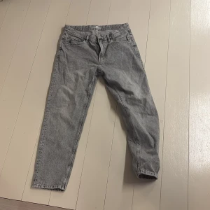 Grå jeans från Bershka - Snygga grå jeans från Bershka i en straight vintage stil. De har en klassisk femficksdesign och är tillverkade i denim. Perfekta för en avslappnad look.