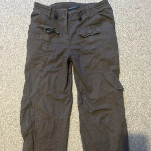 Bruna cargopants med fickor - Snygga bruna cargopants med flera praktiska fickor och snörning i midjan. Perfekta för en avslappnad stil och passar bra till vardags. 