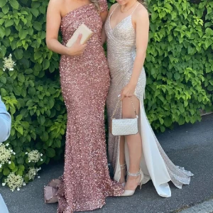 Balklänning  - Snygg rosa glittrig balklänning med oneshoulder-design. Perfekt för en balen både i 9an och 3an. Klänningen har en figurnära passform och är täckt av paljetter som fångar ljuset vackert. Nypris 4300kr💕