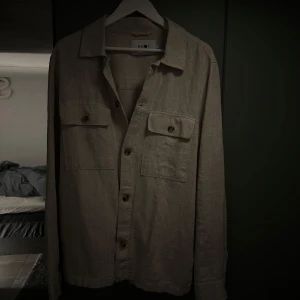 Beige overshirt från NN07 - Säljer nu en riktigt fet och snygg overshirt ifrån märket NN07. Overshirten är aldrig använd då den inte har passat mig. Helt perfekt nu att ha till sommaren eller över en hoodie. Nypris ligger på 2500 kr men mitt pris är 599kr, men kan justeras vid snabb affär😀