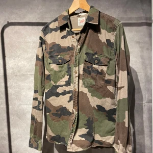 Camo overshirt - Snygg camouflage skjorta/overshirt från Vailent Clothing med långa ärmar och knappar framtill. Skjortan har två bröstfickor med knappstängning och är perfekt för en avslappnad stil.