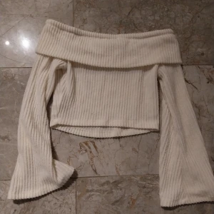 Vit ribbad offshoulder tröja från Shein - Säljer en stilren vit ribbad offshoulder tröja från Shein. Tröjan har långa ärmar och en croppad passform. Säljes pga för liten. Katt finns I hemmet.