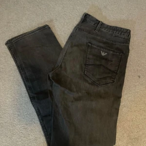 Svarta jeans från Emporio Armani - Snygga grå jeans från Armani med klassisk femficksdesign och logga på bakfickan. Perfekta för en stilren look. Priset är diskuterbart 