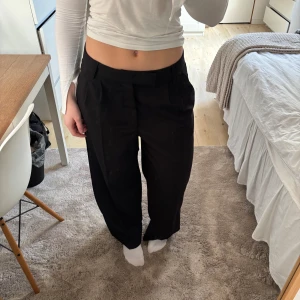 Svarta kostymbyxor från H&M - Snygga svarta kostymbyxor från H&M med rak passform. Dem sitter lågmidjat på mig då jag bruket ha str 36/38 och detta är str 40 