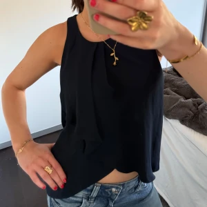 marinblå ärmlös topp - Snygg marinblå ärmlös topp med rund halsringning. Perfekt för en stilren look och kan enkelt matchas med jeans eller kjol. Toppen har en lös passform som ger en bekväm känsla.