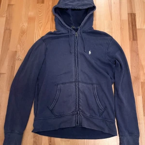Mörkblå hoodie från Ralph Lauren - Säljer en snygg mörkblå hoodie från Ralph Lauren, perfekt för en avslappnad stil. Använd några gånger men skicket är bra. Bara att höra av sig om du har några frågor😊