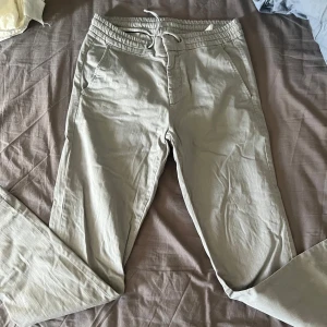 Grå byxor med snörning - Snygga grå byxor med snörning i midjan. De har en avslappnad passform och har fickor på sidorna. 