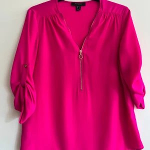 Rosa blus från Atmosphere - Säljer en snygg rosa blus från Atmosphere med dragkedja framtill. Blusen har trekvartsärmar som kan rullas upp och fästas med knapp. Perfekt för en färgglad look! Skriv för fler bilder eller om ni har fler frågor 💓