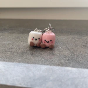 Söta nyckelringar med marshmallowfigurer - Två supergulliga nyckelringar med små marshmallowfigurer i vitt och rosa. Baserade på jellycat gosedjuren! De har glada ansikten och små bruna fötter. Perfekta som accessoar för att ge lite extra charm till dina nycklar eller väskor. 