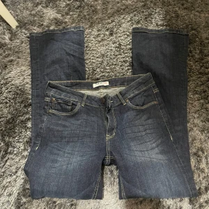 Mörkblå bootcut jeans från Lindex - Säljer ett par snygga mörkblå bootcut jeans från Lindex. De är i bra skick och har en klassisk femficksdesign. Perfekta för både vardag och fest! 🕺