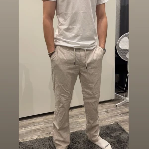 Linnebyxor - Stiliga linnebyxor från Dressmann med bra passform och sköna att ha på sig. Byxorna har använts 3 gånger. Killen på bilden är 184 cm lång och de passar utmärkt på han.