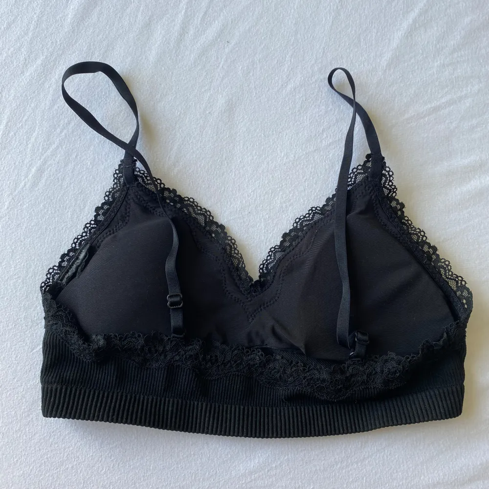 Säljer en snygg svart bralette med ribbad textur och fina spetsdetaljer längs kanterna. Den har justerbara axelband och materialet är jättebekvämt. Knappt använd. 🖤 . Övrigt.