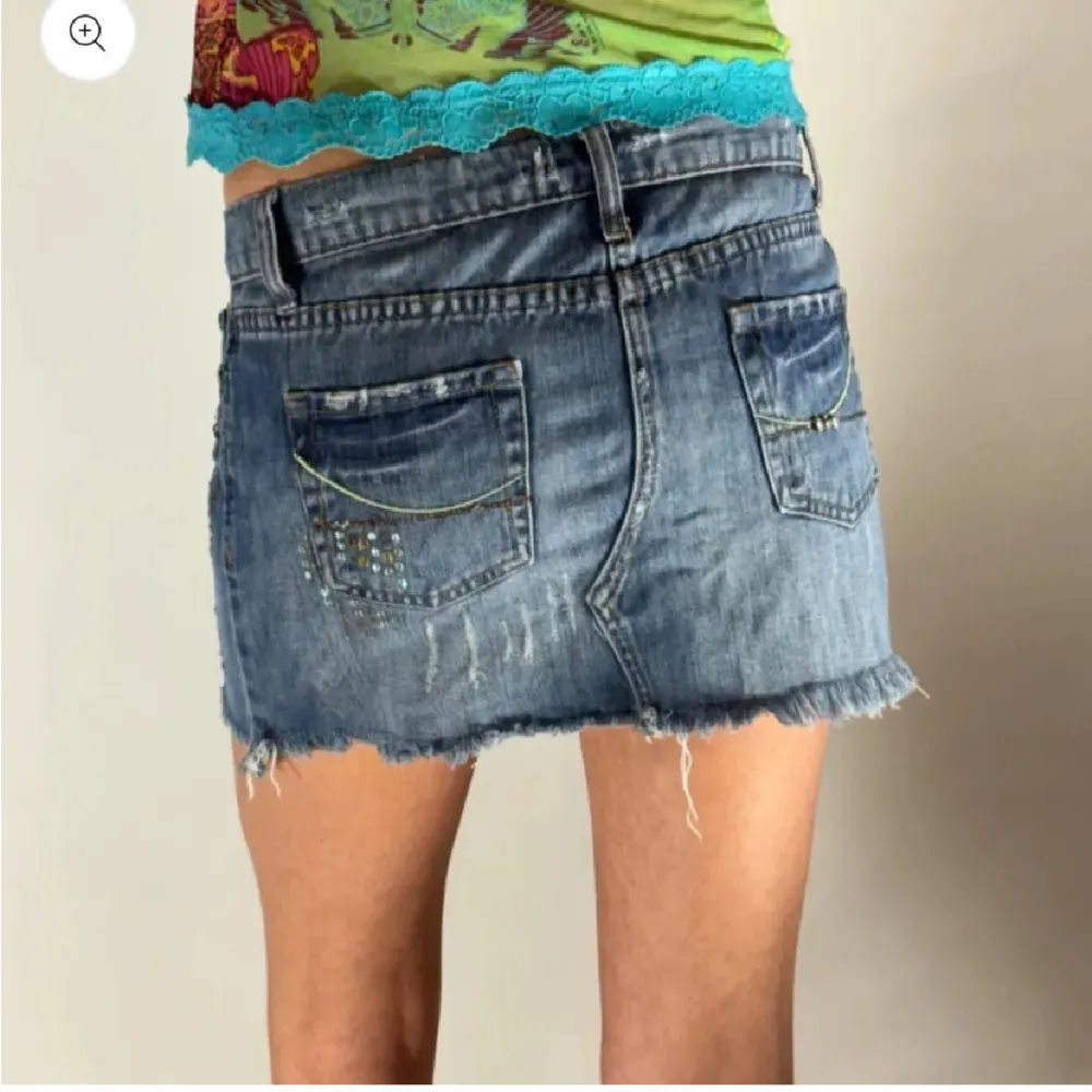 Säljer en supercool jeanskjol från Hippie Groove! Den är kort och har en snygg sliten look med paljettdetaljer som ger lite extra bling. Perfekt för sommaren eller en festlig kväll. Passar perfekt med en färgglad topp eller en enkel t-shirt.. Kjolar.